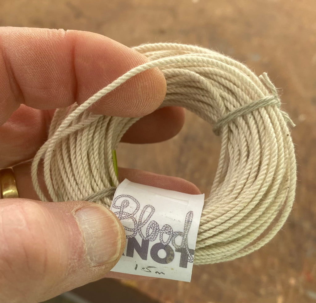 Fine 1.5 mm raw unbleached cotton hard-laid cordage shown against a hand for scale